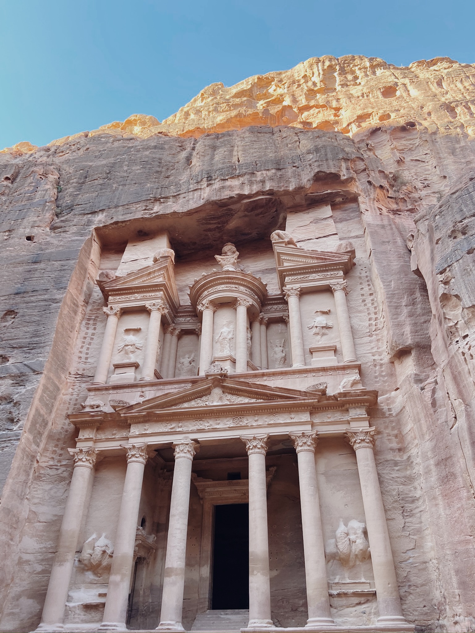 Petra's Treasury facade carved into pink sandstone rock in Jordan